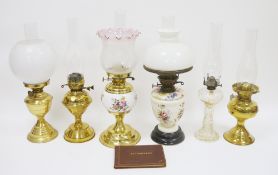 Collection of six oil lamps including an early 20th oil lamp with floral decorated ceramic base,
