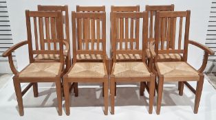 Set of eight pale oak dining chairs in the Cotswold School manner, having slatted backs, rush