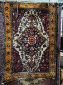 Eastern cream ground rug with large central geometric medallion, floral spandrels and multiple