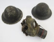 Two WWII Brodie-style British helmets, together with WWII child's gas mask.