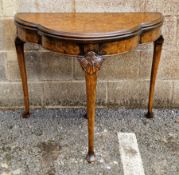 Reproduction figured walnut card table, shaped demi lune, on shell and scroll carved tapering