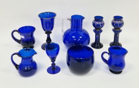 Collection of Bristal blue glass to include four jugs, wine glass, bowl, pair of candle holder or
