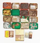 Quantity of Meccano parts in tins to include gear wheels, flexible plates, triangle plates, bolts,