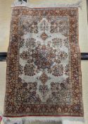Persian silk cream ground rug with central floral motif, floral spandrels and multiple herati