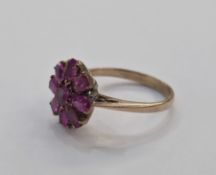 Gold coloured and ruby dress ring, flowerhead design having nine oval rubies, 3.gm total approx,