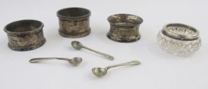 Three silver napkin rings, silver mustard spoon and a silver mounted glass dish, weighable silver