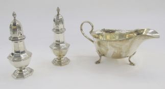 Pair of silver Georgian-style Edward VII pepperettes and a George V sauceboat, the pepperettes