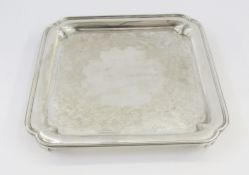 Victorian silver salver, square with incuse corners, beaded edge, scroll engraved, on four tab feet,