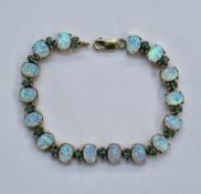 9ct yellow gold, please note SYNTHETIC opal and emerald line bracelet comprising 16 oval claw set