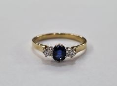 18ct yellow gold, sapphire and diamond three-stone ring comprising a central oval cut blue