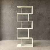 A contemporary white modular open bookshelf of five asymmetrical alcoves in the manner of Heals. H.
