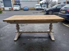 A farmhouse style extending oak refectory table with two pull out leaves, on painted turned and