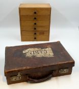 A mid century pine collector's chest of drawers along with small early 20th century leather travel