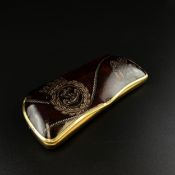 An early 20th century silver plated glasses case having a leather clad lid printed with ropes and