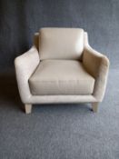 A contemporary beige leather and textile armchair on short tapered supports by Roche Bobois. W.