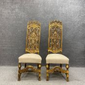 A pair of profusely carved Italian style giltwood high back hall chairs each having a scrolling