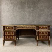 A large French Empire style mahogany desk having a gilt tooled green leather top with a ormolu