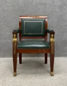 A Regency style mahogany arm chair having a rolled top rail above a tooled green leather back seat