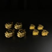 A set of four gilt metal cap feet of scrolling foliate design along with a set of four brass lion'