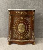 A 19th century style pier cabinet with marble top above shaped panel door with ormolu mounts on