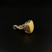 A 19th century cast and engraved white metal fob seal inset with a translucent yellow stone. (