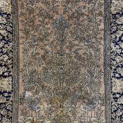A Persian style tree of life carpet having a central symmetrical design with a vase, flowers,