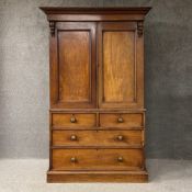A 19th century mahogany linen press having a moulded cornice supported by a pair of carved corbels