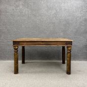 A 20th century Indian hardwood dining table having a rectangular top with iron studs and straps