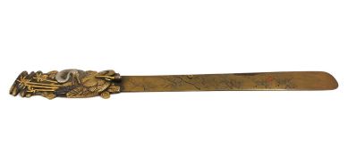 A signed Japanese brass letter opener with an engraved blade and a crane and bamboo design in relief