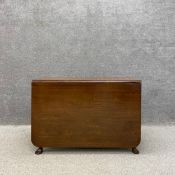 A 19th century Georgian style mahogany drop leaf table having a rectangular top over a moulded