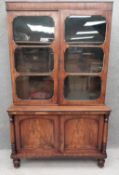 A Victorian mahogany library bookcase in two parts; the upper section having a square cornice over