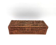 A Chinese sandalwood box carved allover in relief with scholars, bridges and pagodas among trees.