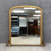 A 19th century gilt overmantel mirror with an arched moulded frame with carved scrolling