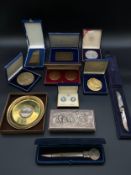 A collection of various commemorative items from banks and airlines to include five coins, a pair of