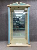 A large Neoclassical style display cabinet with a shaped pediment above four glass shelves set