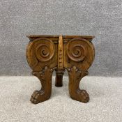 A 19th century continental solid walnut tripod table base heavily carved with scrolling corbel