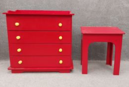 A pillar box red chest of four drawers with yellow handles for a child's bedroom along with a
