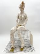 A mixed media abstract seated maquette/figure with chicken wire, mod rock, and string, titled '