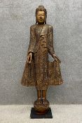 A large 20th century South East Asian painted and giltwood hand carved Buddha figure intricately