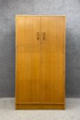A mid century 'Brandon' oak double wardrobe by E Gomme for G-Plan with a teak interior and an