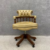 A late 20th century Captain's swivel desk chair with a sand coloured scrolled leather button back