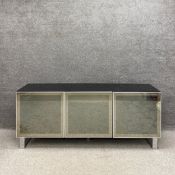 A contemporary black and chrome sideboard having a composite laminated top above three mirrored