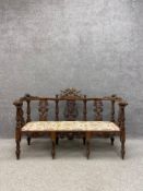 A 19th century Italian Renaissance Revival walnut parlour settee having a green man with twin