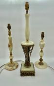 A collection of three mid century turned onyx and cast, embossed and pierced brass table lamps of