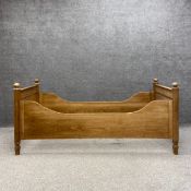 A 19th century pitch pine single bedstead with high shaped sides and panelled head and foot boards