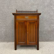 A C.1900 Robert Strahan & Co. Dublin Aesthetic Movement walnut dwarf pier cabinet having a gallery