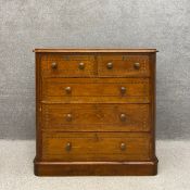 A C.1900 Aesthetic Movement stained pine chest of drawers with a rectangular moulded top above two