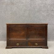 A Georgian oak mule chest having a two plank hinged top over a panelled trunk above two lower