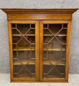 A C.1900 oak library bookcase section with marquetery inlay and astragal glazing to doors