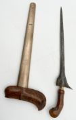 An Indonesian style Kris knife with a carved hardwood handle and white metal blade and scabbard. L.
